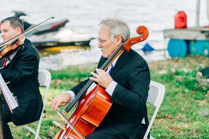 Live string music played for the backyard wedding ceremony on the lake.