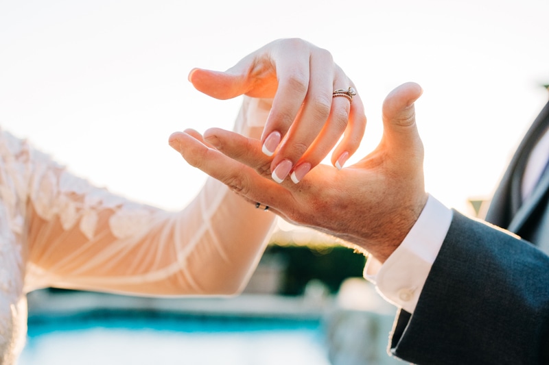 Wedding Photographer, the hands of bride and groom meet to hold each other