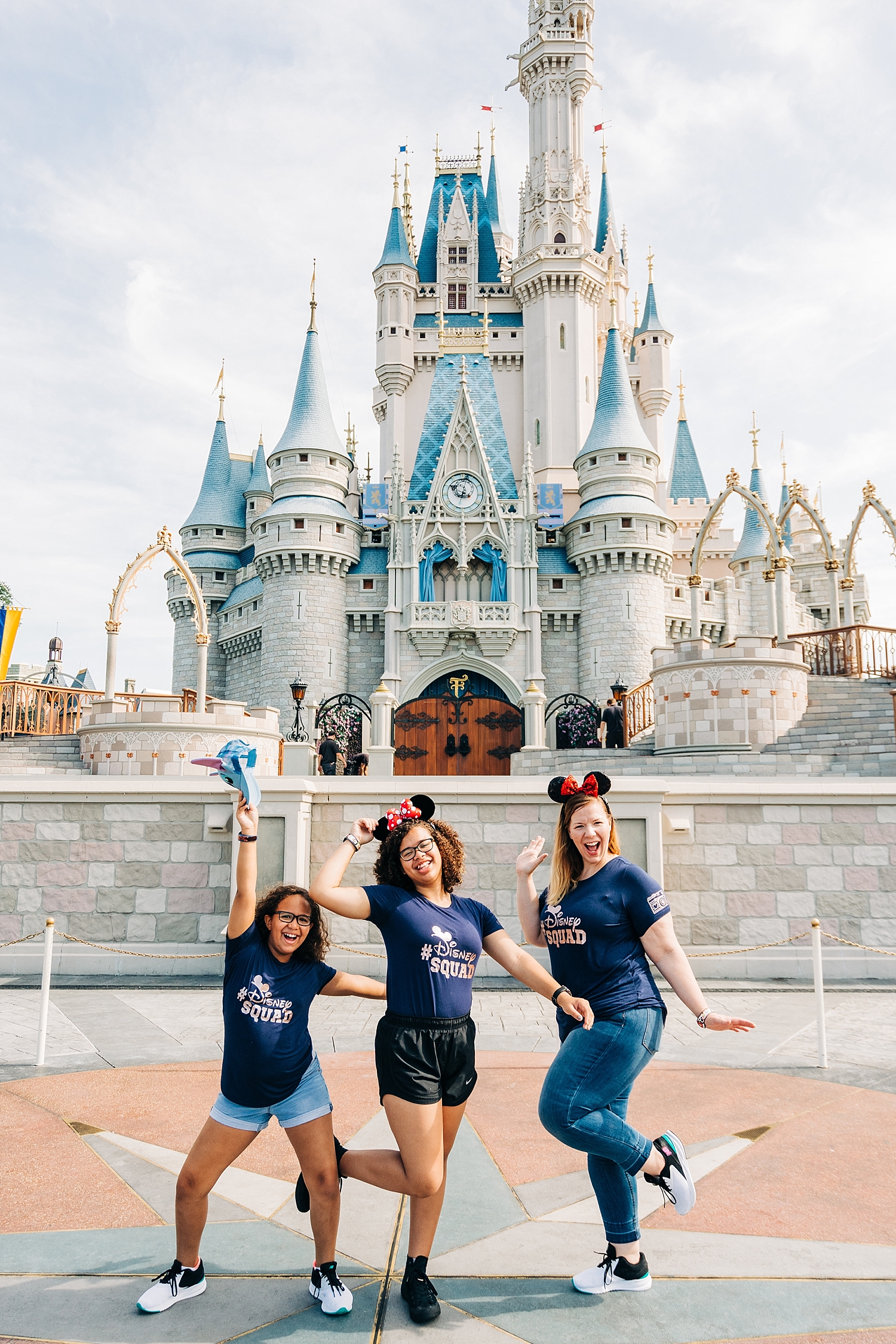 Mother and daughters strike instagram worthy pose in front of Cinderella’s castle