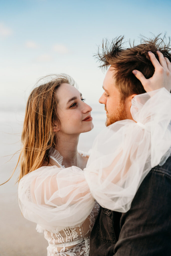 Wedding Photographer, newly married husband and wife gaze into each other's eye's at the beach