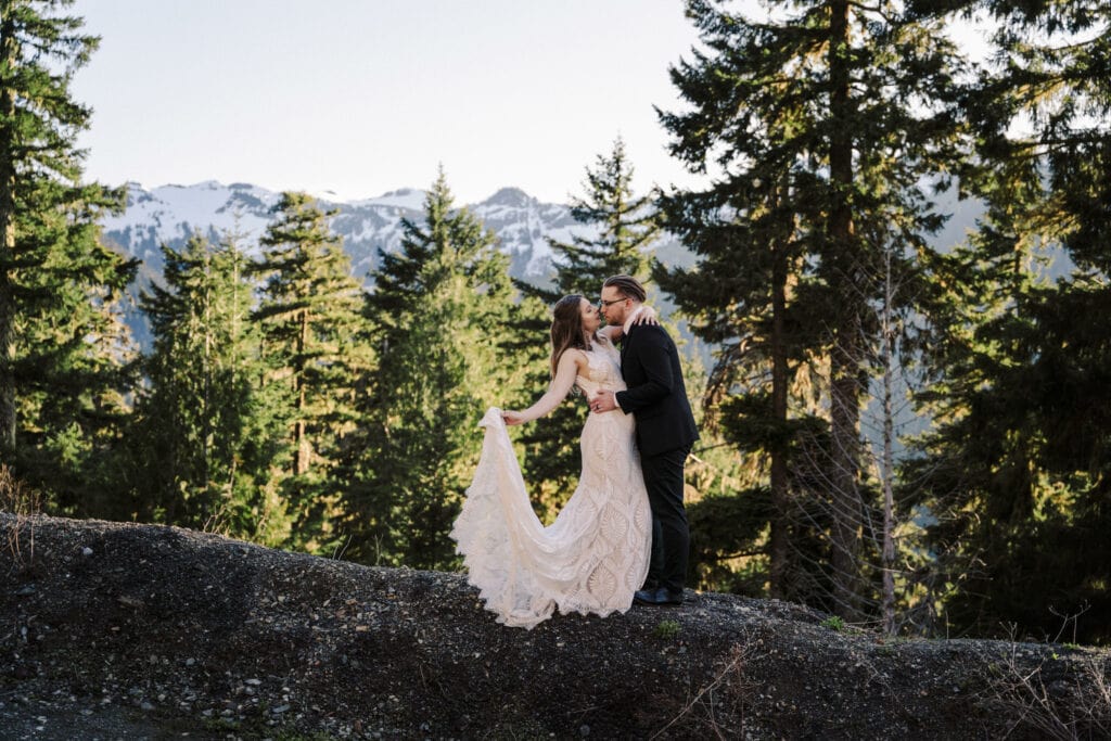 couple kisses against a backdrop of mountains