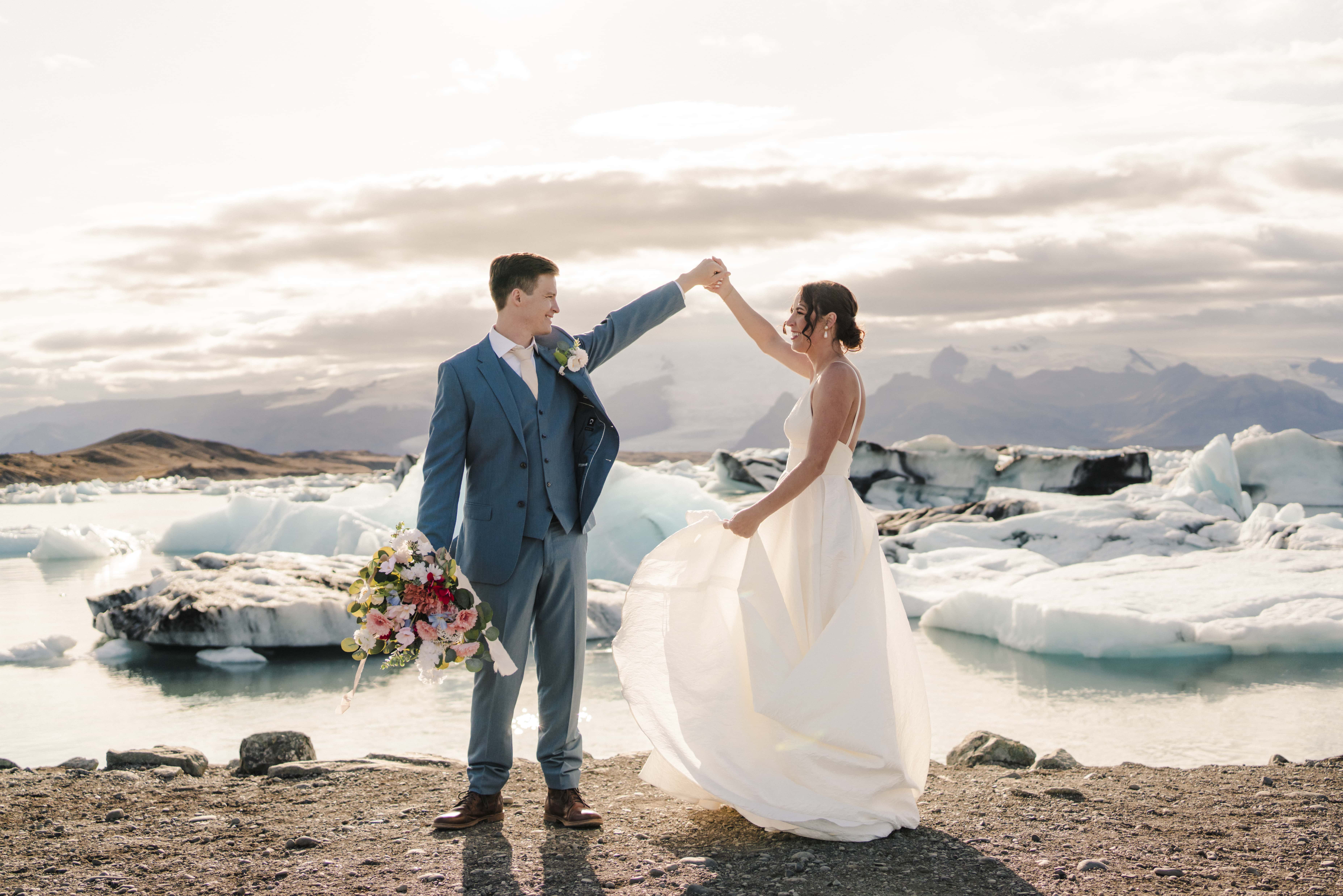 bride and groom stand in front of the glacier lagoon in Iceland